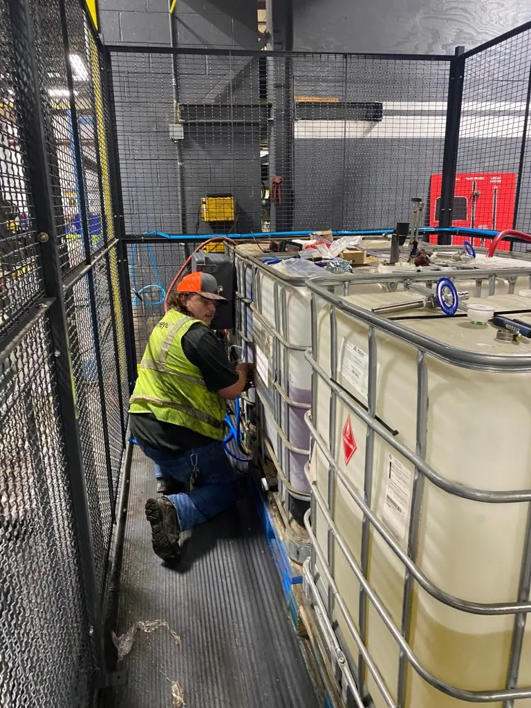 Technician servicing a detergent tote dispensing system